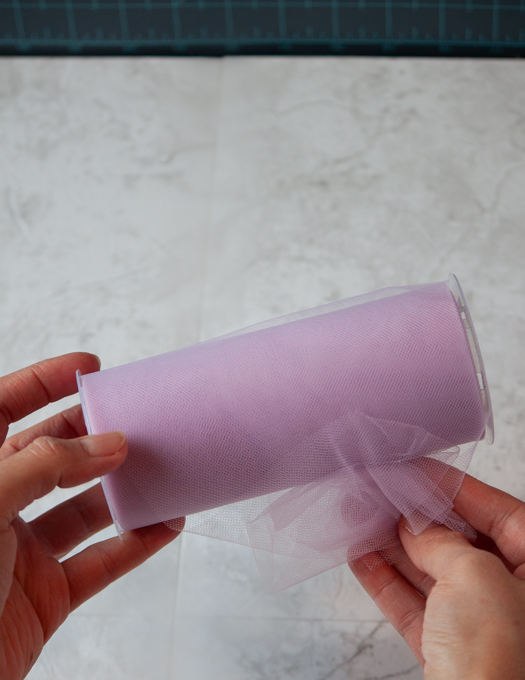 pink tulle roll hold in 2 hands to show the color