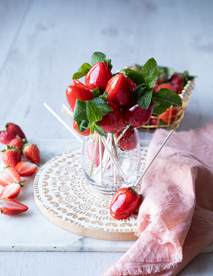 alternative presentation of the candied strawberries recipe is serving them in a cup or vase to look like flowers with some fresh mint