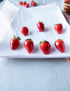 diped candied strawberries on a parchment paper on a baking sheet
