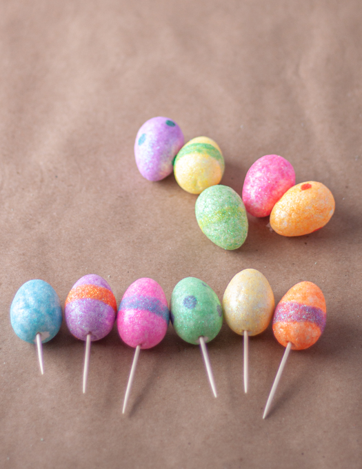 different colors of small easter eggs with toothpicks attached at bottom of each eggs