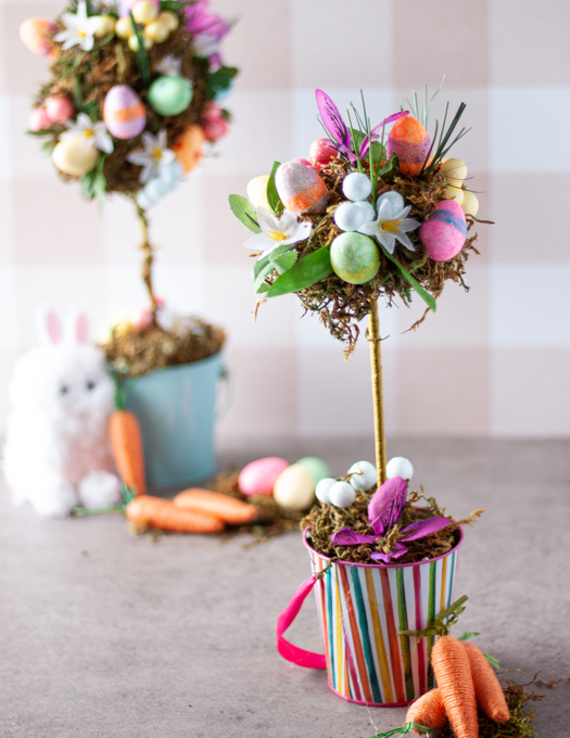 smaller topiary tree in a colourful bucket decorated with eggs, flower, grass and moss
