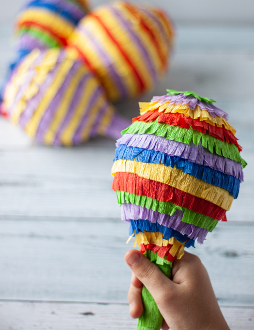 fully decorated Mini Pinata being hold by a little hand ready to be smashed