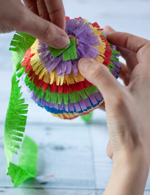Final row of crepe paper being applied into the Mini Pinata