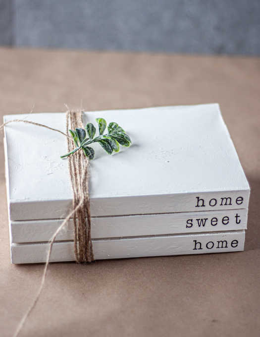 Stamped book stacks wrapped in twine with a green stem on top